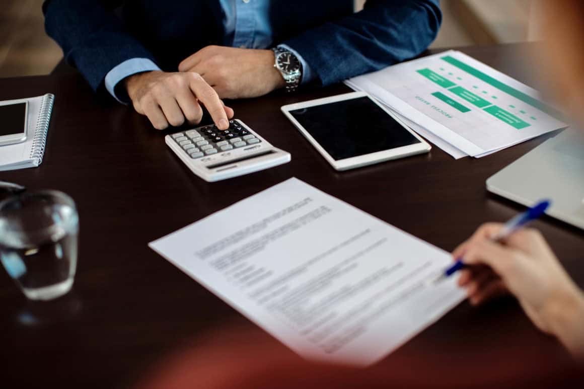 Un courtier et sa cliente, en train de signer un contrat de rachat de crédits.