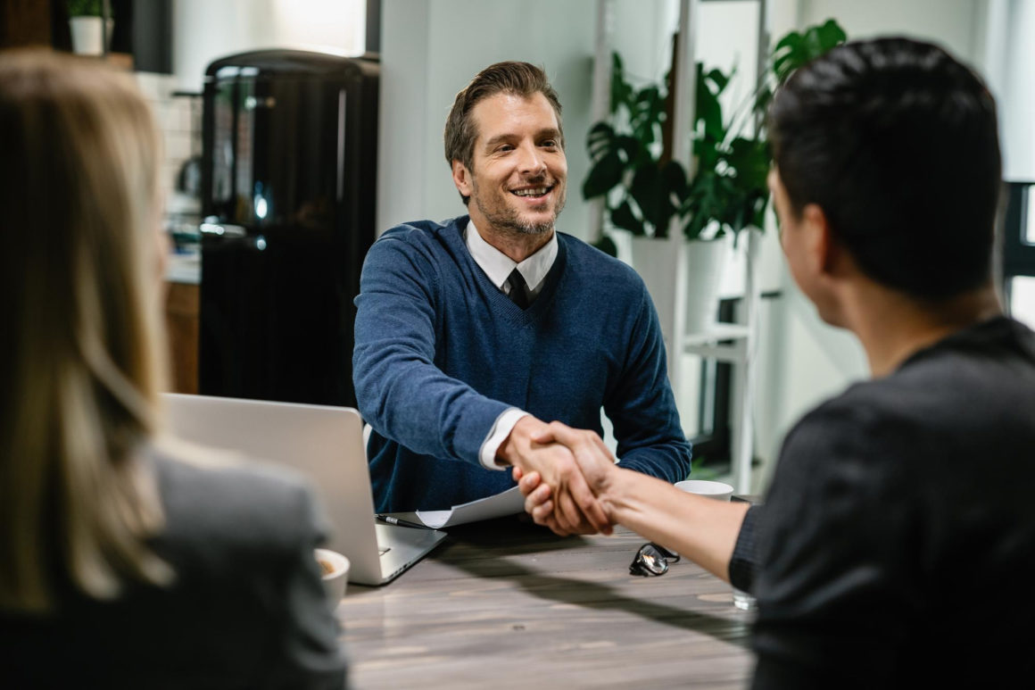 Un courtier en train de serrer la main à ses clients.