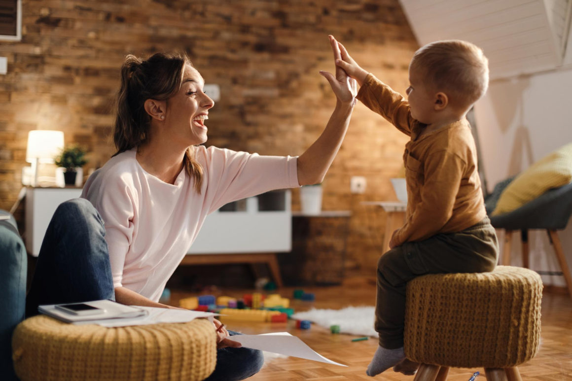 Jeune maman tapant dans la main de son bébé.